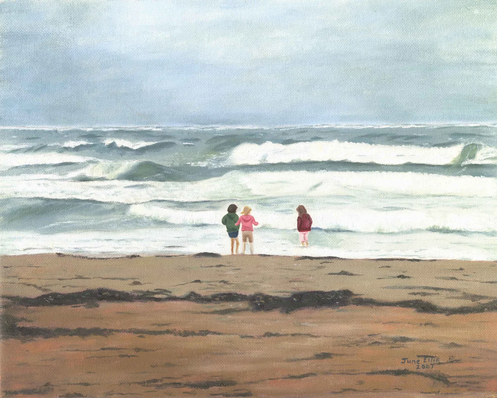 Three little girls playing in the waves at the shore