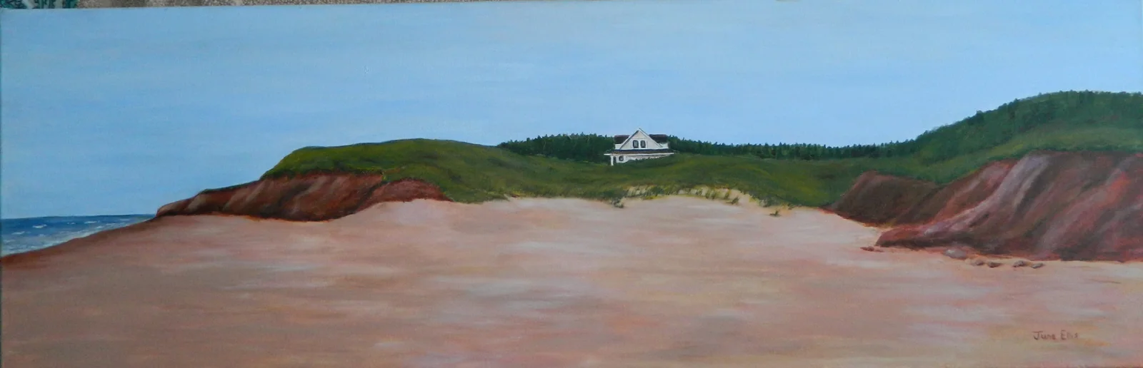 Sandy beach with cottage in the background and dunes